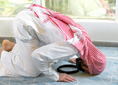رجل سعودي خليجي ملتزم باتباع اجراءات السلامة بوضع الكمامة بشكل صحيح اثناء الصلاه  ، تجنب انتشار العدوى ، صلاه العيد