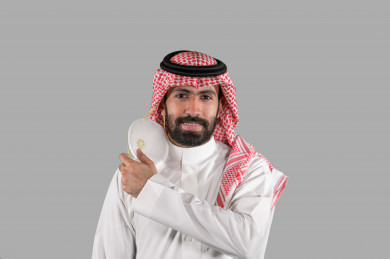 بورتريه لشاب سعودي يقوم بوضع الكمامة ، اتباع اجراءات السلامة بوضع الكمامة بشكل صحيح ، تجنب انتشار العدوى ، خلفية بيضاء