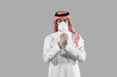 بورتريه لشاب سعودي يقوم بارتداء القفازات ، اتباع اجراءات السلامة بارتداء القفازات ، تجنب انتشار العدوى ، خلفية بيضاء