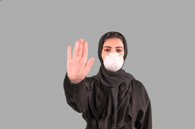 بورتريه لفتاه سعودية ترتدي الكمامة ، ترفع يدها لتجنب المصافحة واقتراب الاخرين منها ، تجنب انتشار العدوى ، الحفاظ على المسافات ، خلفية بيضاء