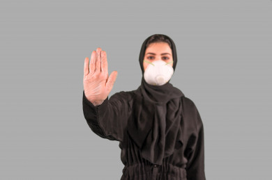بورتريه لفتاه سعودية ترتدي الكمامة ، ترفع يدها لتجنب المصافحة واقتراب الاخرين منها ، تجنب انتشار العدوى ، الحفاظ على المسافات ، خلفية بيضاء