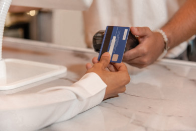 رجل عربي سعودي يقوم بالدفع عند الاستقبال بطريقة الكترونية باستخدام البطاقة ، السداد الالكتروني في متجر القهوه