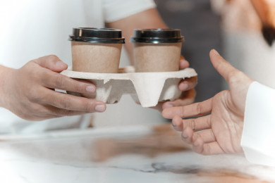 رجل عربي سعودي يحمل اكواب القهوه  بيده ، استلام الطلب ، متجر القهوه